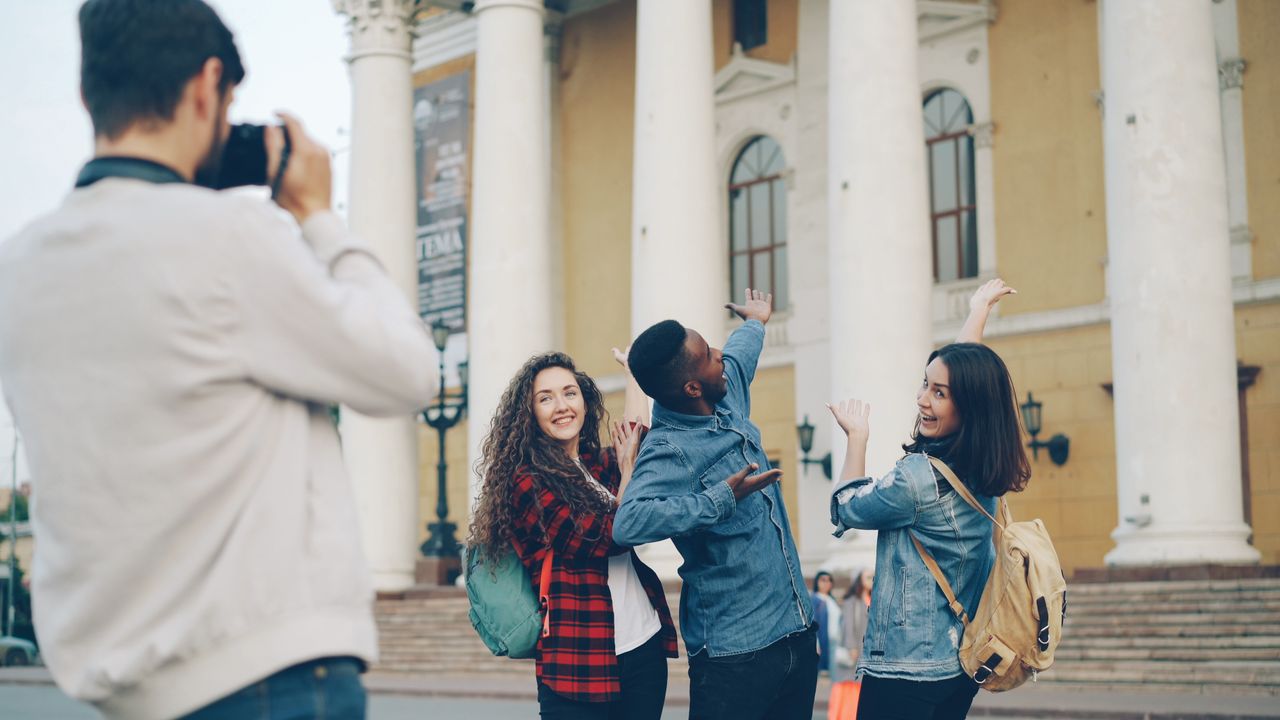 Group of friends posing outdoors in front of historic building with columns.
