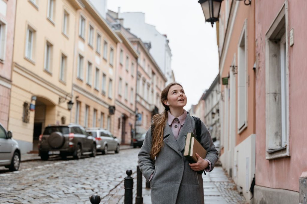 Mastering the First Impression: Your intriguing post title goes here A young woman enjoys walking in a charming cobblestone city street lined with historic buildings.